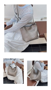 Detail of silver metallic woven tote bag featuring wide intrecciato style and single handle