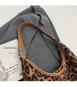 Detail eines bequemen braunen Leder-Schultergurts an einer Tragetasche mit Leopardenmuster