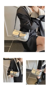 Close-up of silver metallic underarm bag with double front utility pockets and zipper