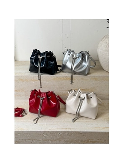 Détail de sacs seaux en cuir verni brillant en noir, argent, rouge et beige avec chaîne