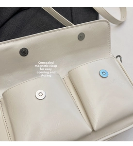 Detail of cream crossbody bag featuring hidden magnetic closure and dual inner pockets