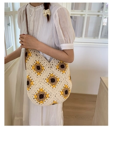 Detailed close-up of handmade crochet shoulder bag featuring floral sunflower patterns