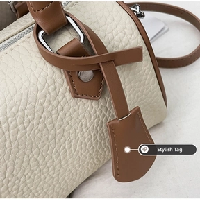 Detail of lychee pattern leather contrast color Boston bag with silver hardware