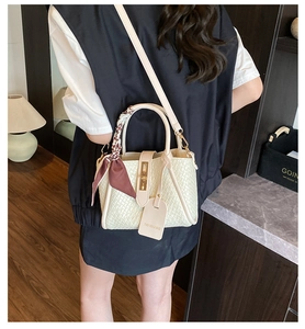 Cream woven textured handbag with floral scarf and gold lock shown on shoulder