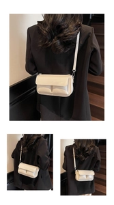 Detail showing dual front pockets and embossed Paris lettering on cream square bag