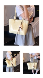 Détail du sac cabas jaune crème avec texture crocodile, lanières et charm ours