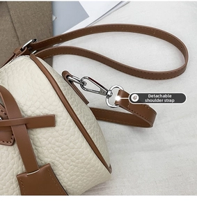 Detail of silver metal lobster clasp and detachable shoulder strap on leather handbag