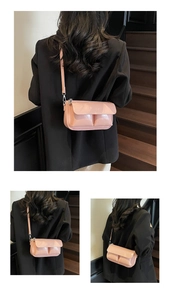 Detail view of pink patent leather baguette bag with PARIS engraving and front pockets