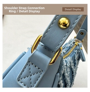 Detailed close-up of light blue denim and faux leather shoulder bag with golden hardware