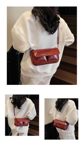 Detailed view of red glossy crossbody bag featuring Paris embossed logo and double pockets