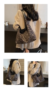 Detailansicht der Leopard-Print-Tragetasche mit schwarzen Lederriemen im Café-Ambiente