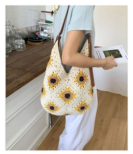 Detail of hand-woven sunflower shoulder bag with leather strap and crochet texture