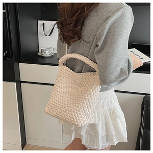Détail du tissage crème d'un grand sac à bandoulière élégant avec poignée souple
