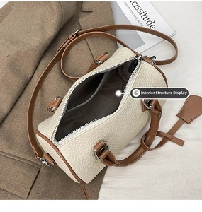 Interior structure of the cream barrel bag showing the grey herringbone lining and pocket