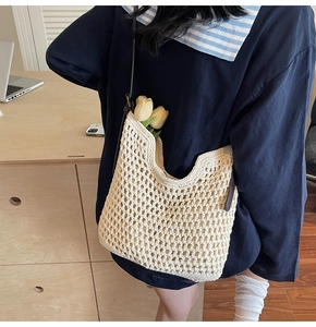 Detail of hand-woven cotton crochet tote bag with leather strap and hollow mesh texture