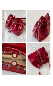 Detail view of red patent leather bucket bag with silver chain and beige lining