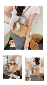 Détail d'un sac seau tissé marron clair avec fermoir en métal et foulard en soie