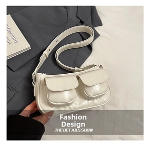 Detail shot of white glossy underarm bag featuring two functional front flap pockets