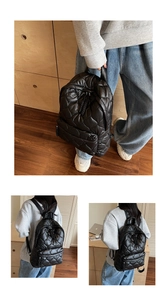 Detail of black quilted puffer backpack showing soft texture and large diamond pattern