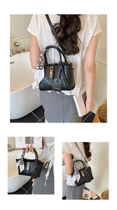 Détail du sac seau noir tressé avec fermoir métallique, étiquette en cuir et foulard