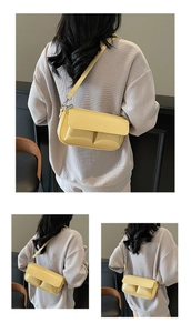 Detail view of yellow leather baguette bag featuring front pockets and PARIS lettering