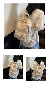 Detail of champagne gold quilted backpack with adjustable straps and front zipper pocket