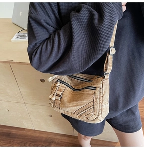 Close-up of vintage washed canvas crossbody bag with multiple pockets and wide strap