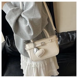 Macro shot of off-white lychee leather texture and silver buckle on a shoulder bag