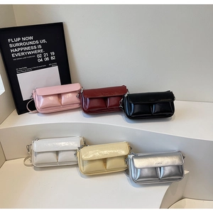 Detail of glossy crossbody mini square bags with PARIS embossing and dual front pockets