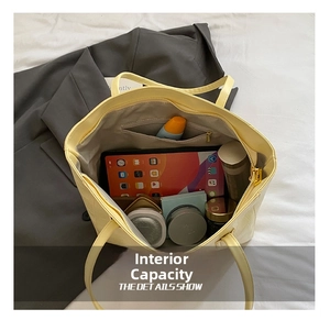 Détail de l'intérieur spacieux d'un sac cabas jaune avec poche zippée et objets divers