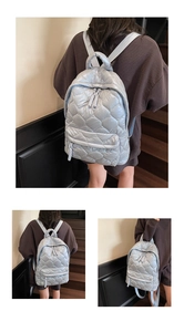 Detail of light blue quilted down backpack with diamond stitching and adjustable straps