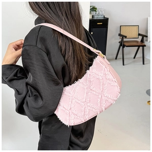 Detail of pink frayed denim shoulder bag with quilted texture and gold hardware accents