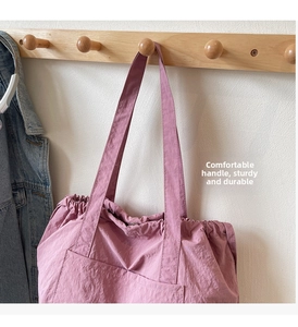 Detail of dusty rose large tote bag showing durable nylon texture and wide shoulder strap