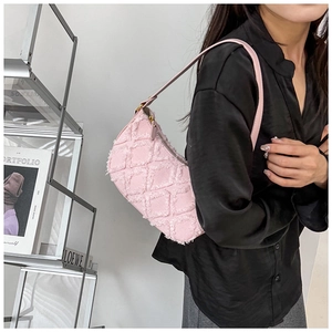 Detail of pink denim hobo bag with quilted rhombus pattern and frayed edge textures