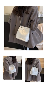 Detail of silver bucket bag with metallic pleated texture and fine chain strap