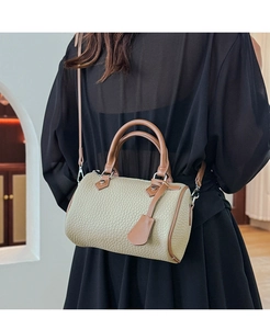 Rear view of model wearing olive green lychee grain leather Boston bag with brown trim