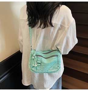 Detailed view of mint green multi-pocket denim crossbody bag shown on model for daily look