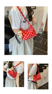 Detail view of red polka dot bucket bag with a cute beige plush bear pendant accessory