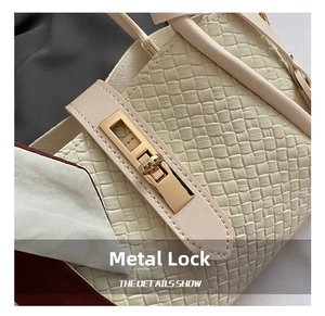 Close-up of golden metal twist lock and woven leather texture on cream bucket bag