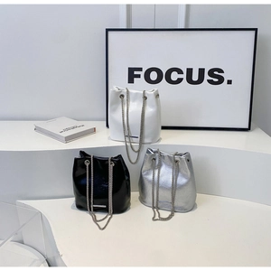Detailed display of fashion bucket bags in black, white and silver with chain straps