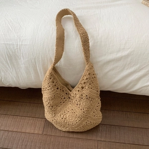 Detailed macro view of beige crochet hobo bag with intricate petal knit patterns