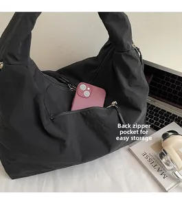 Detail of the back hidden zipper pocket on a large black nylon tote bag for smartphones