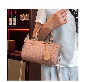 Detail of nude pink pebble leather Boston bag with dual handles and adjustable strap