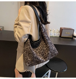 Detail der Vintage-Einkaufstasche mit Leopardenmuster, Lederriemen und weicher Hobo-Form