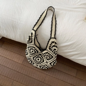 Macro view of handmade crochet tote bag with black and white floral geometric patterns