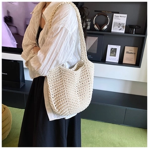Close-up of beige woven shoulder bag showing dense crochet pattern and thick cotton rope