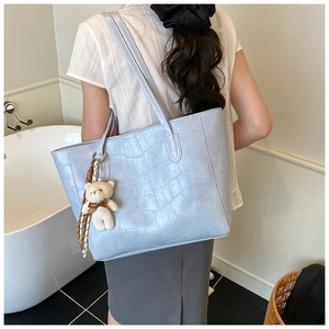 Détail d'un grand sac fourre-tout bleu clair en cuir synthétique à motif croco