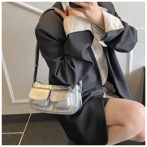 Close-up of a silver metallic baguette bag featuring functional double front flap pockets