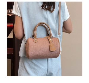 Detailed macro view of pebble grain leather and stitching on the pink Boston handbag