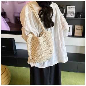 Detail of hand-woven beige tote bag showing intricate hollow rope mesh pattern